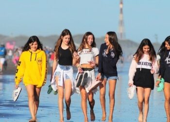 Adolescentes caminando por la playa