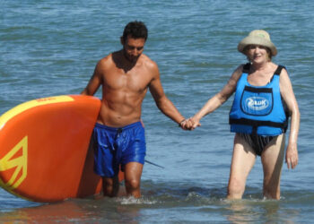 Jonatan Millan y Lidia saliendo del mar después del debut en la tabla