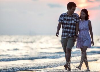 Pareja de novios caminando por la playa