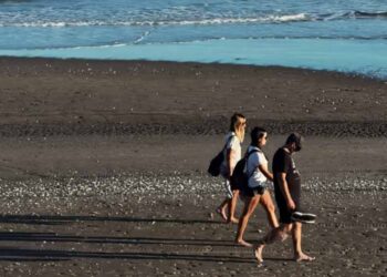 Turistas caminando por la playa