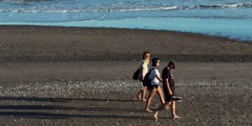 Turistas caminando por la playa