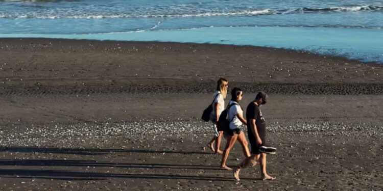 Turistas caminando por la playa
